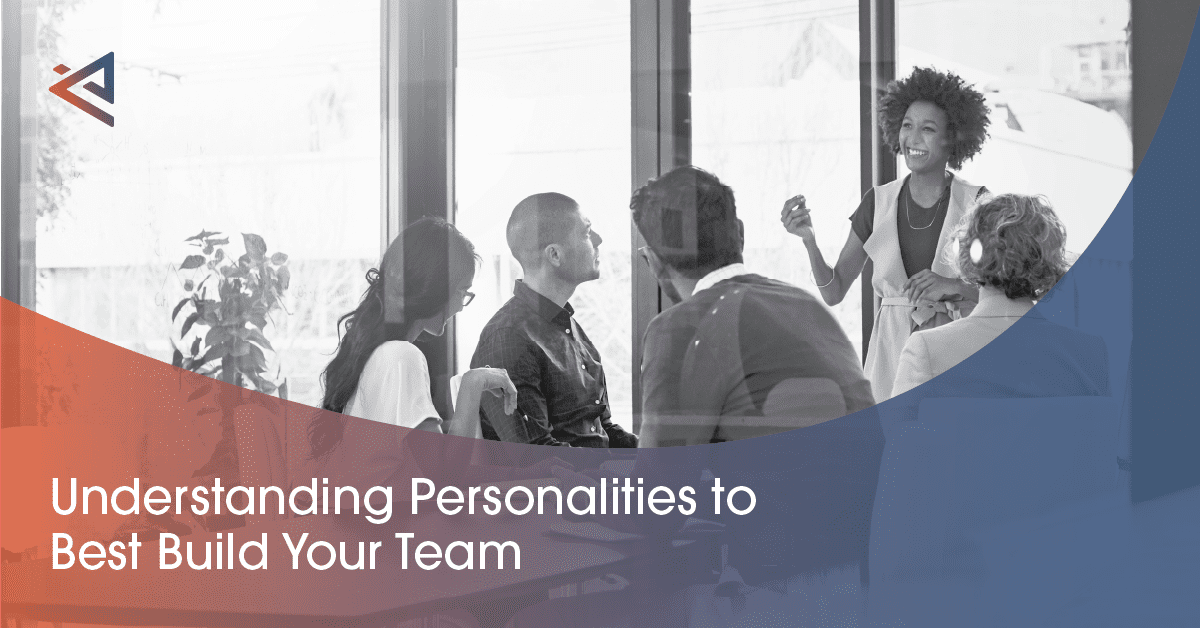 Conference full of men and women looking at a female speaker with curly hair standing and speaking