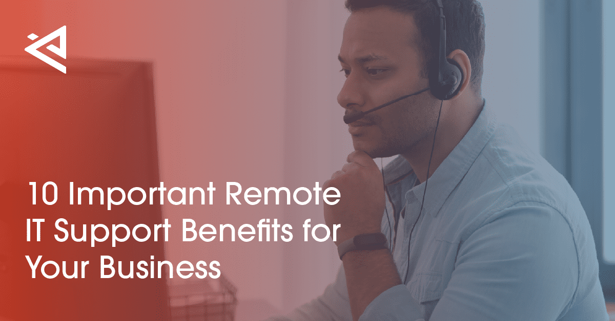 a man with dark hair sitting at a computer desk with a headset on